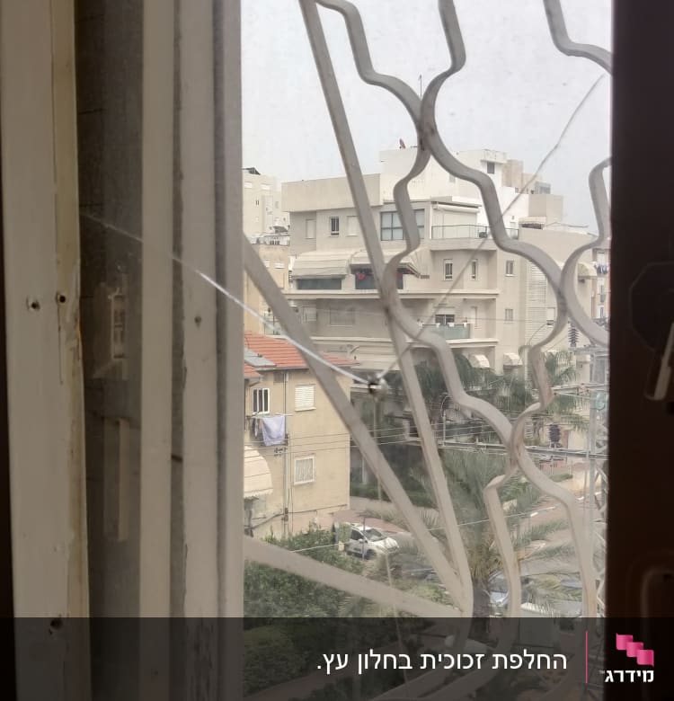 חלון עם תריסים שבורים ומסגרת מתכת מעוצבת